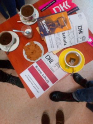 Zdjęcie ze spotkania - stolik z kawą, ciasteczkami i twórczością Bruno Schultza