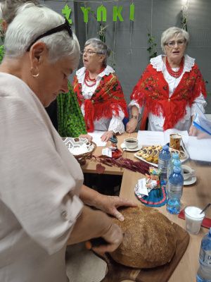 Zdjęcie z dożynkowego spotkania z zespołem Ojry Bis - krojenie bochenka chleba
