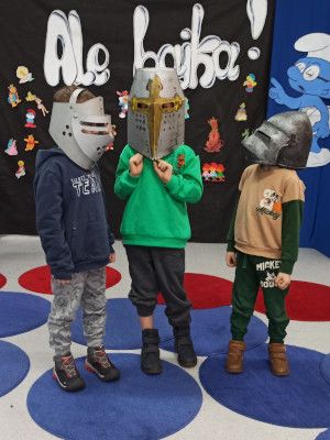 Zdjęcie z zajęć - trzej chłopcy przebrani za rycerzy podczas improwizowanego przedstawienia