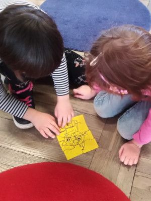 Zdjęcie z zajęć - dzieci układające 'kocie' puzzle